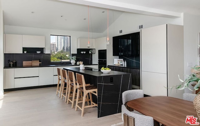 kitchen featuring white cabinets, decorative light fixtures, and a kitchen island