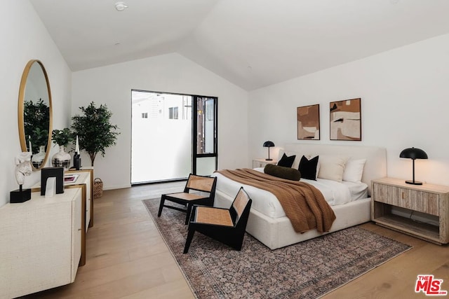 bedroom with vaulted ceiling and light hardwood / wood-style flooring