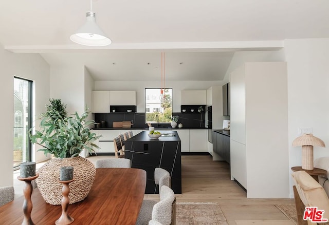 dining area with plenty of natural light, sink, and light hardwood / wood-style flooring