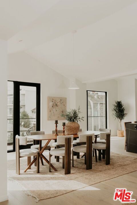 dining space featuring light hardwood / wood-style flooring and lofted ceiling