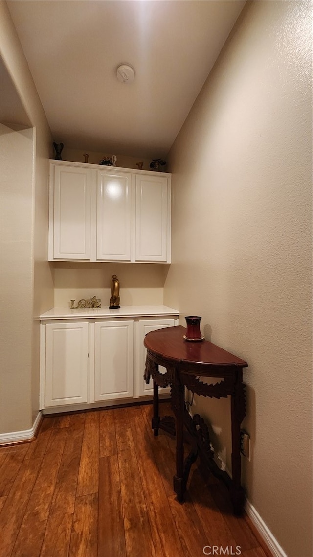 bar featuring white cabinetry and hardwood / wood-style floors