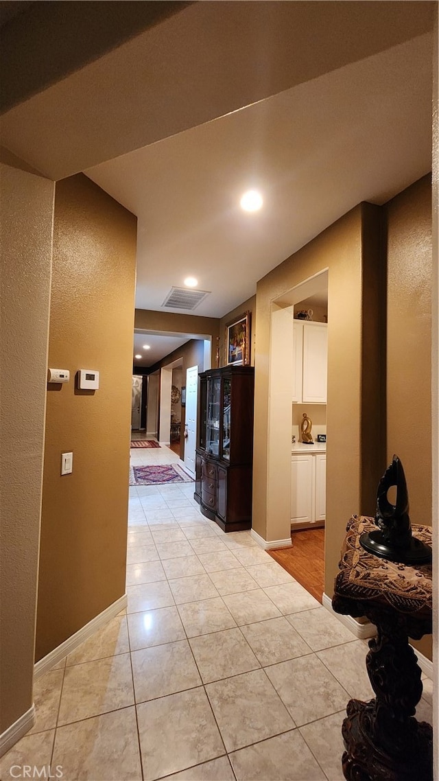 hall with light tile patterned floors