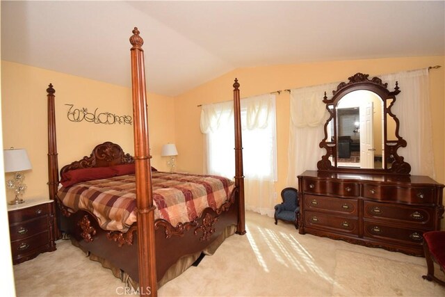 bedroom featuring vaulted ceiling and light colored carpet