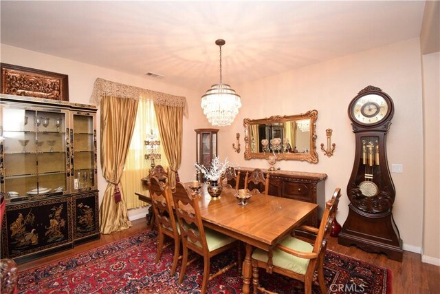 dining area with a chandelier and dark hardwood / wood-style floors