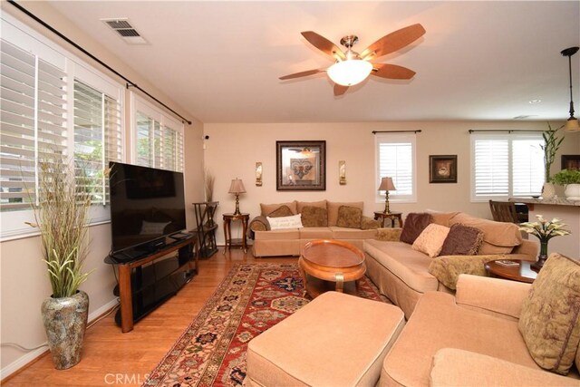 living room featuring light wood-type flooring and ceiling fan