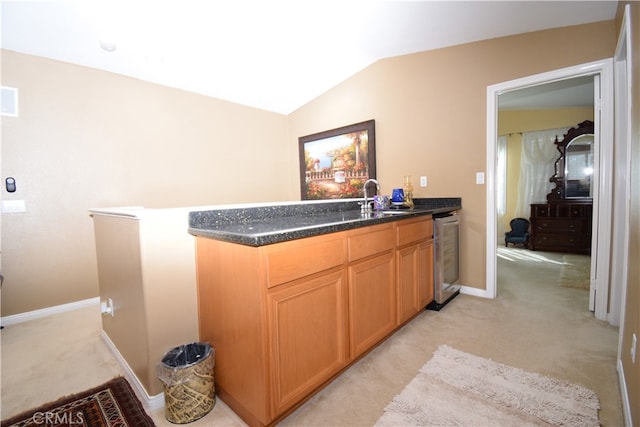 kitchen with beverage cooler, light colored carpet, sink, and vaulted ceiling