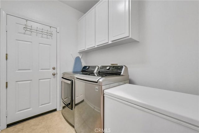 washroom with light tile patterned floors, separate washer and dryer, and cabinet space