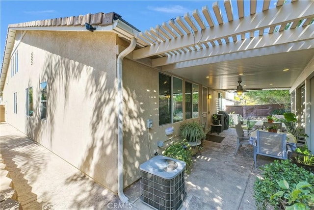 view of patio featuring central AC unit, outdoor dining area, fence, a ceiling fan, and a pergola