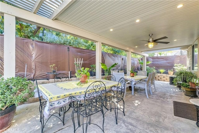 view of patio with a fenced backyard, a ceiling fan, and outdoor dining space