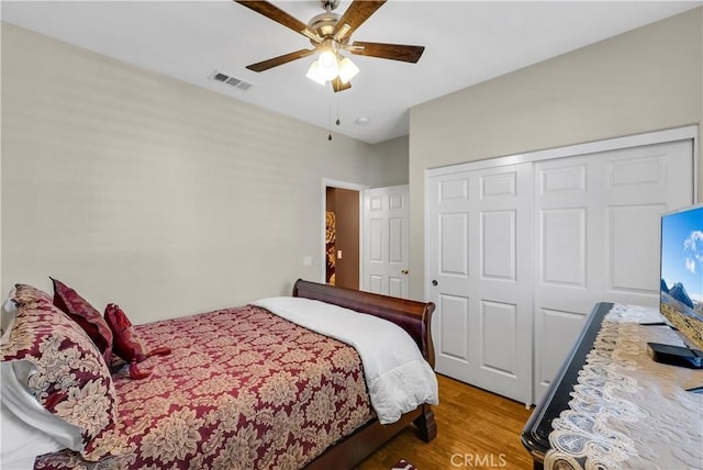 bedroom featuring a closet, visible vents, ceiling fan, and wood finished floors