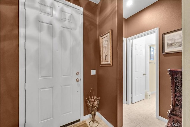 entryway with light tile patterned floors and baseboards