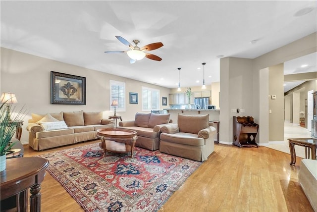 living room with ceiling fan, light wood finished floors, recessed lighting, and baseboards