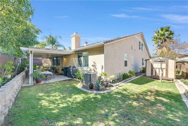 rear view of house with a patio, central AC unit, a storage shed, an outdoor structure, and stucco siding