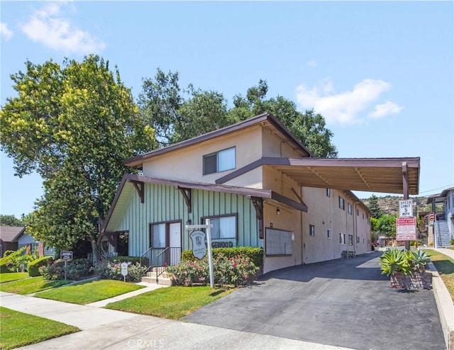 view of front facade featuring a front yard and a carport