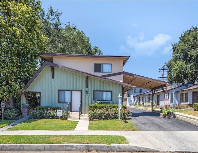 view of front of house featuring a carport and a front yard