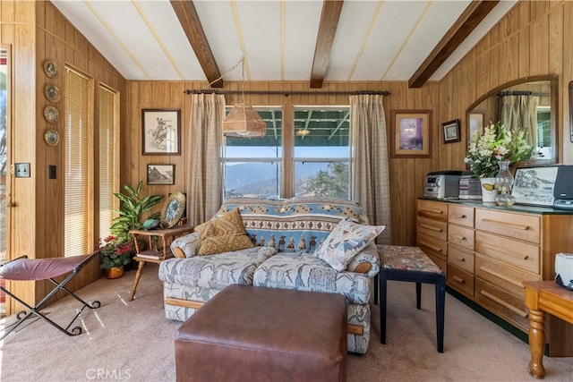 living area with wood walls, light colored carpet, and vaulted ceiling with beams