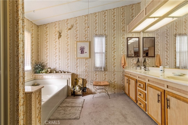 bathroom with a bathtub, vaulted ceiling, and vanity