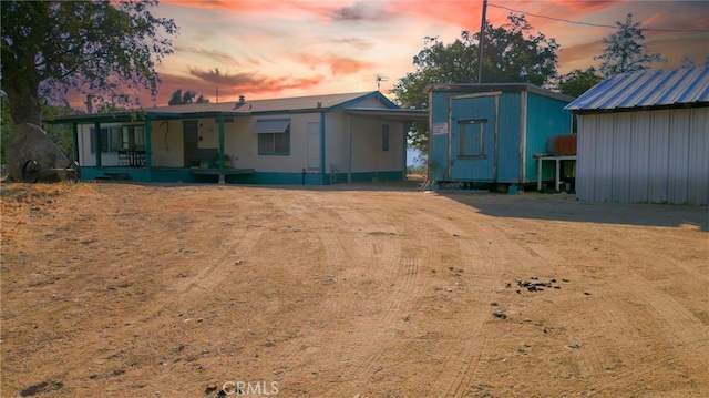 back house at dusk featuring a storage unit