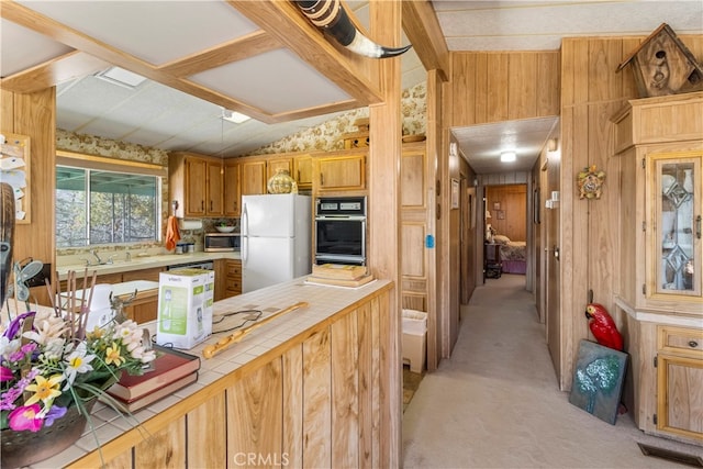 kitchen featuring white refrigerator, wood walls, light colored carpet, tile counters, and vaulted ceiling with beams