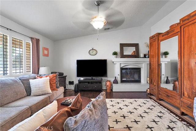 living room with ceiling fan, dark hardwood / wood-style floors, and vaulted ceiling