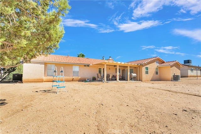 back of property with central air condition unit and a patio area