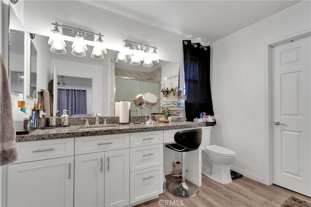 bathroom with vanity, a shower, hardwood / wood-style floors, and toilet