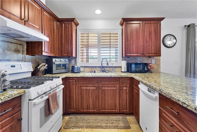 kitchen featuring light stone counters, sink, white appliances, and tasteful backsplash