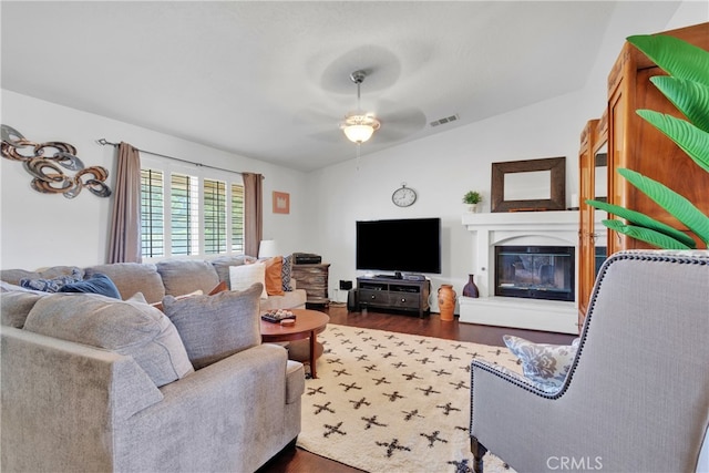 living room featuring ceiling fan, vaulted ceiling, and dark hardwood / wood-style flooring