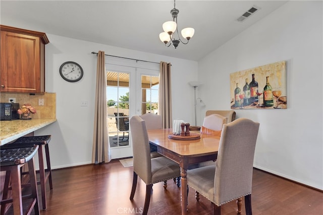 dining room with french doors, vaulted ceiling, a chandelier, and dark hardwood / wood-style flooring