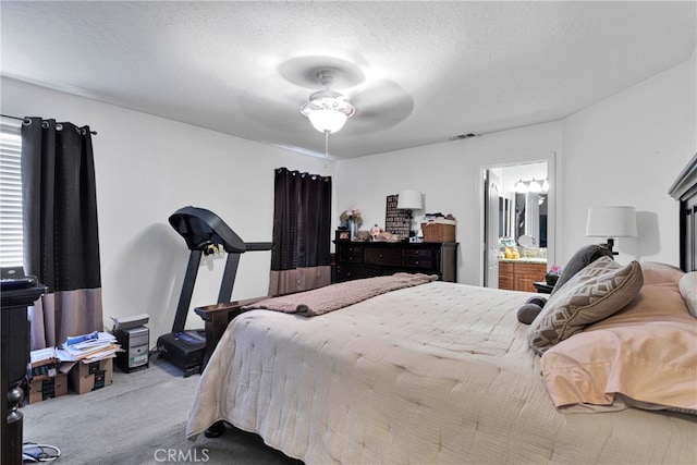 carpeted bedroom with ceiling fan, a textured ceiling, and connected bathroom