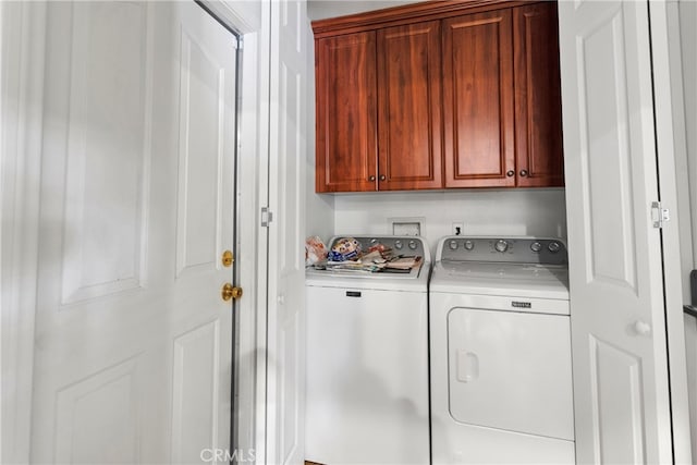 laundry room featuring independent washer and dryer and cabinets