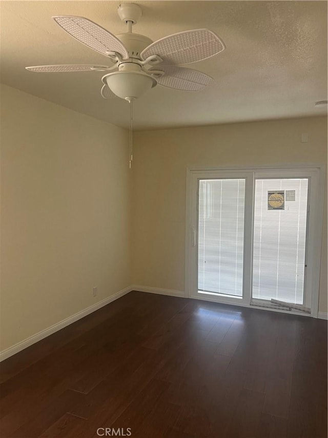 empty room with ceiling fan, dark hardwood / wood-style flooring, and a textured ceiling