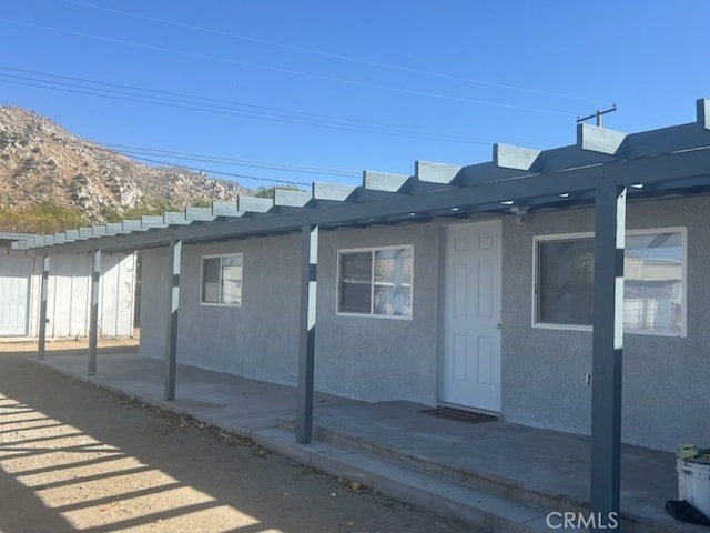 view of side of property with a mountain view and a patio area