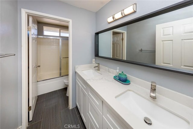 full bathroom with vanity, toilet, and bath / shower combo with glass door