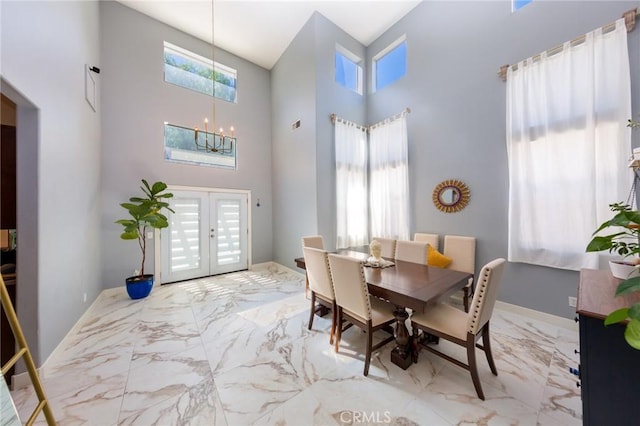 dining room featuring a chandelier, french doors, and a towering ceiling