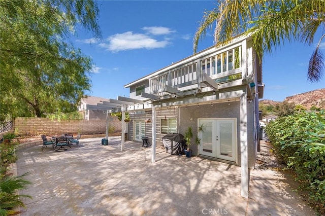 view of patio / terrace featuring french doors, a pergola, and a balcony