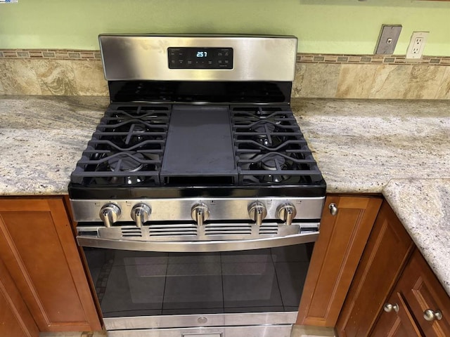 details featuring stainless steel gas stove and light stone countertops