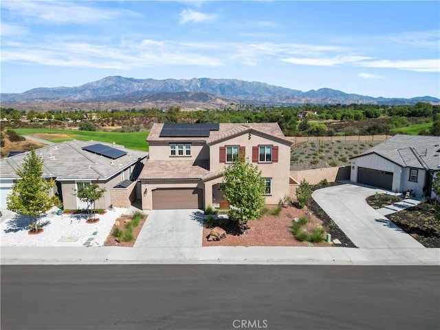 view of front of house featuring a mountain view, a garage, and solar panels