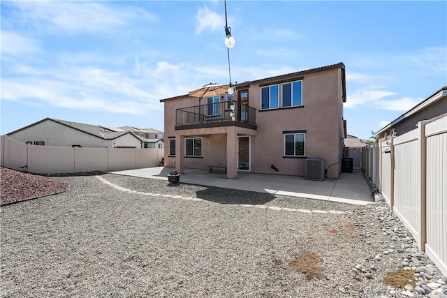 rear view of house with cooling unit, a patio area, and a balcony