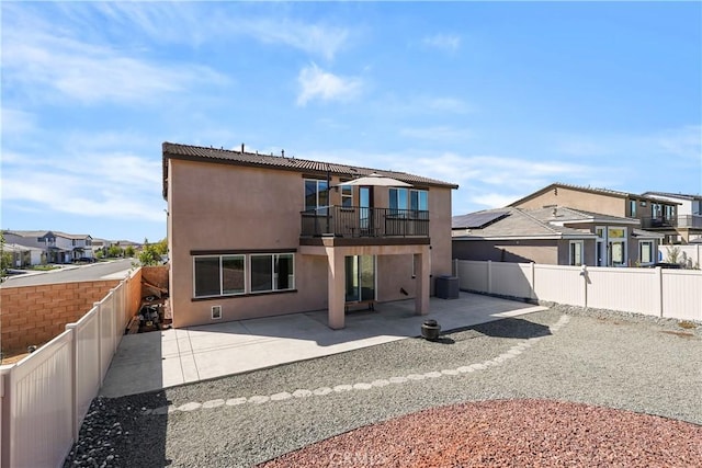 rear view of property featuring a balcony and a patio