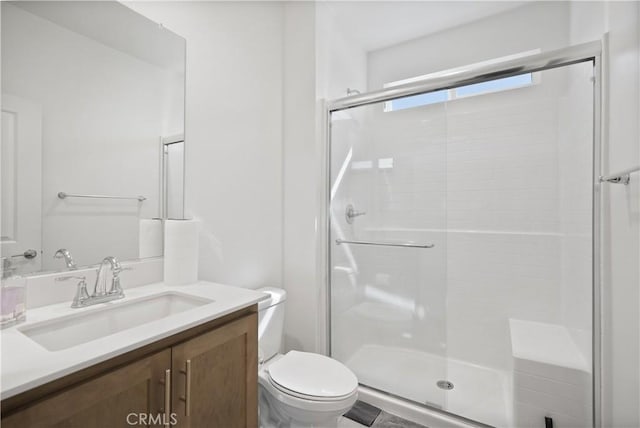 bathroom with toilet, a shower with shower door, and vanity