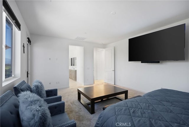 carpeted bedroom featuring ensuite bath