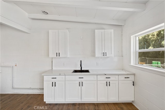 kitchen with vaulted ceiling with beams, dark wood-type flooring, sink, and white cabinets