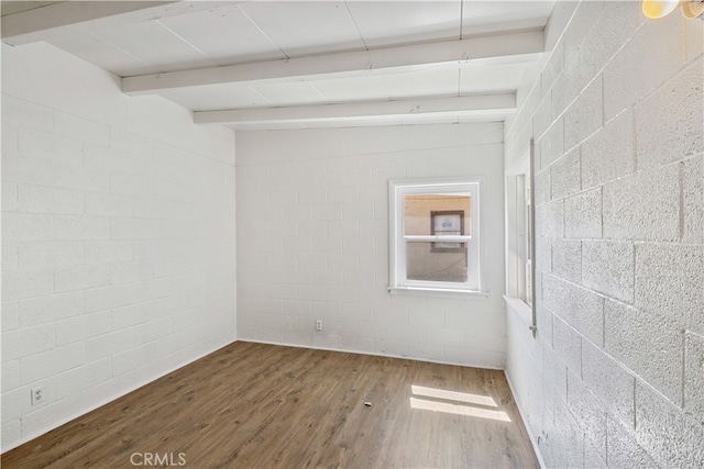 unfurnished room featuring beamed ceiling and wood-type flooring