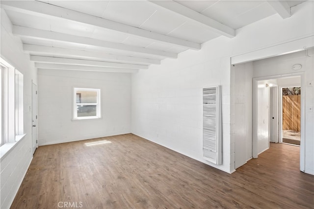 empty room featuring lofted ceiling with beams and dark hardwood / wood-style flooring