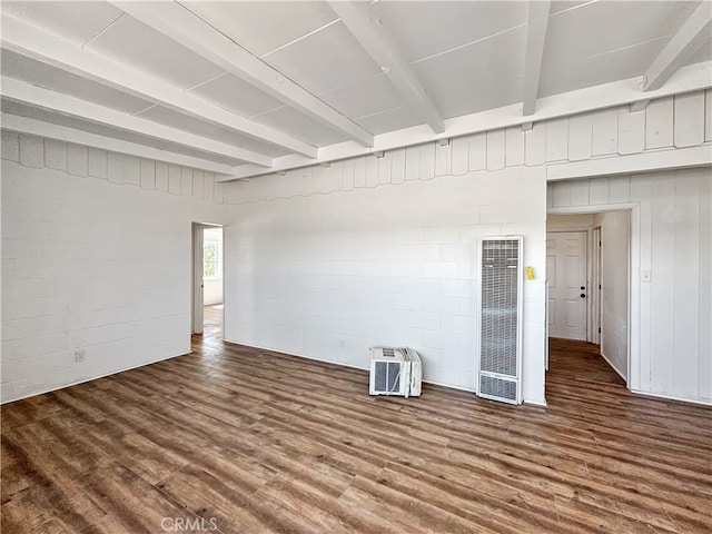 spare room featuring beamed ceiling and hardwood / wood-style flooring