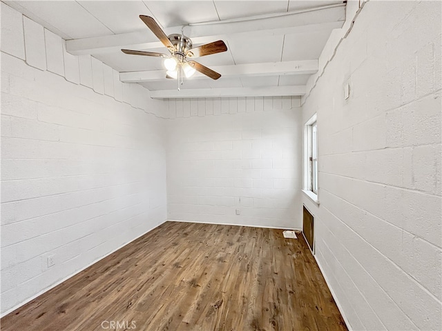 empty room with wood-type flooring, beam ceiling, and ceiling fan