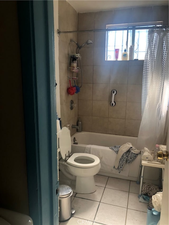 bathroom featuring tile patterned floors, toilet, and shower / tub combo with curtain