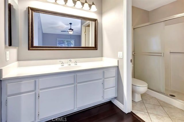 bathroom with vanity, a shower with shower door, toilet, and tile patterned floors