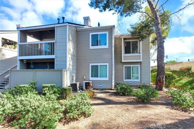 rear view of house with central AC and a balcony